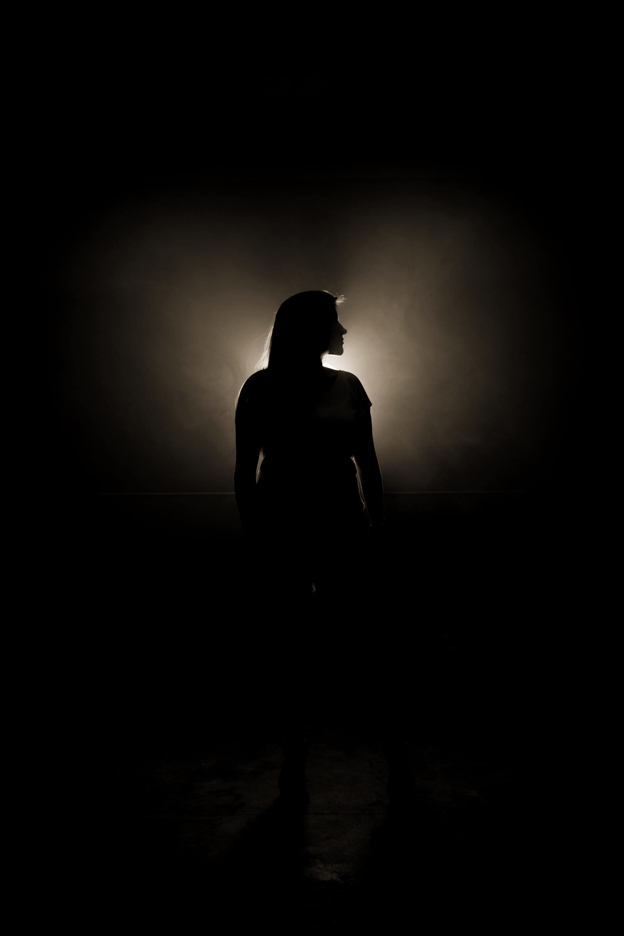 A figure standing in a doorway of light